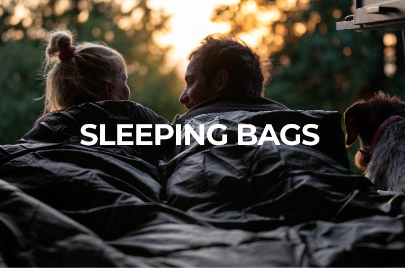 Shop Sleeping Bags: Image shows a couple snuggled up in a TETON Sports mammoth double sleeping bag facing away from the camera.